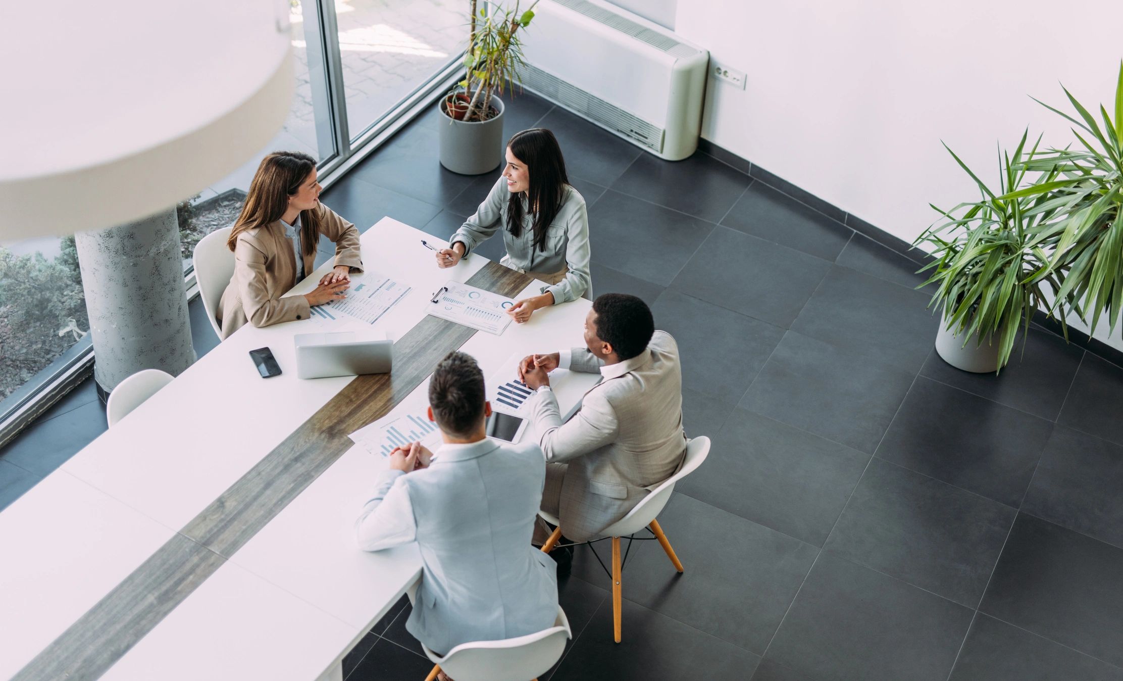 Business team reviewing strategy from above in a conference room