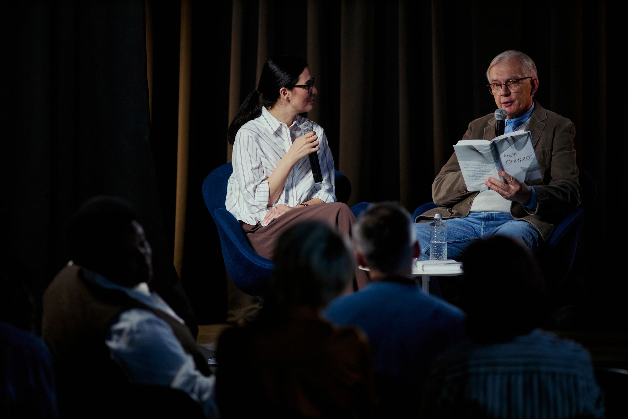 Executive speaker and moderator on stage at a business event